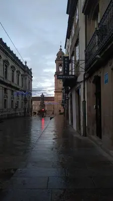 an empty city street with a clock tower in the distance at PICO SACRO II HOTEL Santiago de Compostela in Santiago de Compostela