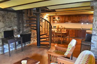 a living room with a kitchen and a dining room at Apartamentos Casa de Riba in Teijeira