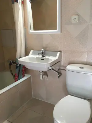 a bathroom with a white toilet and a sink at San Nicolas el Real in Villafranca del Bierzo