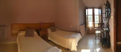 a bedroom with two beds and a window at San Nicolas el Real in Villafranca del Bierzo