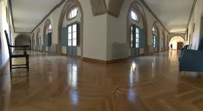 a large room with a wooden floor and windows at San Nicolas el Real in Villafranca del Bierzo