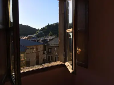 an open window with a view of a city at San Nicolas el Real in Villafranca del Bierzo