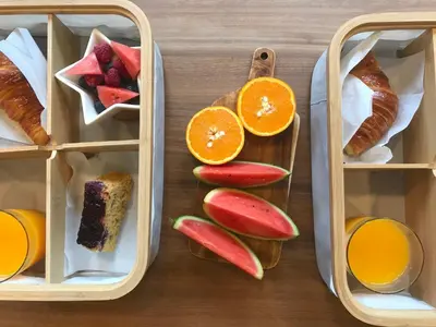 a lunch box with fruits and croissants and bread at Hotel Garelos Betanzos in Betanzos