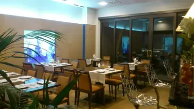 a restaurant with tables and chairs in a room at Hotel Garelos Betanzos in Betanzos