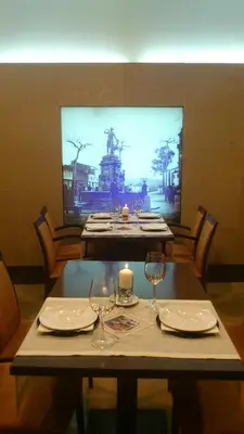 a table with two glasses and a candle on it at Hotel Garelos Betanzos in Betanzos