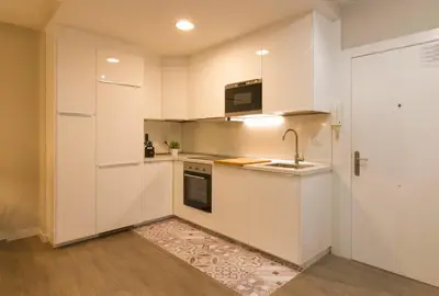 a small kitchen with white cabinets and a sink at Céntrico Burgas Termal in Ourense