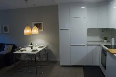 a kitchen with white cabinets and a small table at Céntrico Burgas Termal in Ourense