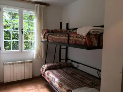 a bedroom with two bunk beds and a window at Os Arroxos in Trabadelo