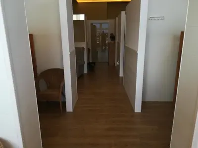 a hallway leading into a room with white walls and wood floors at Albergue Ultreia in Arzúa