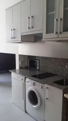 a white kitchen with a washing machine in it at Albergue Ultreia in Arzúa