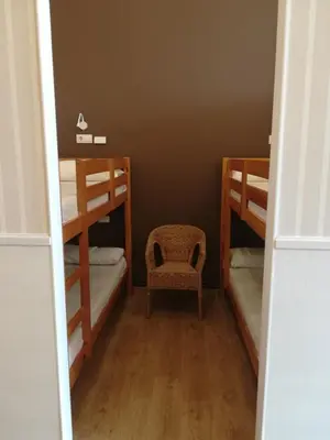 a room with two bunk beds and a chair at Albergue Ultreia in Arzúa