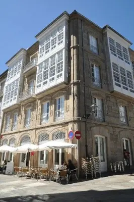 a large building with tables and chairs in front of it at Hotel Pazo de Altamira in Santiago de Compostela