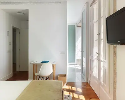 a room with a table and a chair and a television at Hotel Pazo de Altamira in Santiago de Compostela