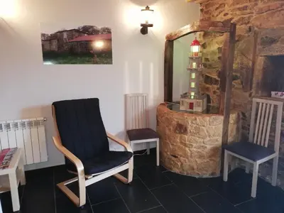 a room with a chair and a table and a mirror at Hosteria Calixtino in Palas de Rei