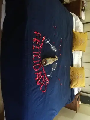 a bed with a blue blanket with red beads and a knife at Hosteria Calixtino in Palas de Rei