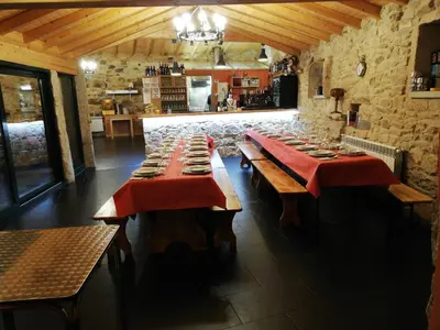 a dining room with long tables with red table cloth at Hosteria Calixtino in Palas de Rei