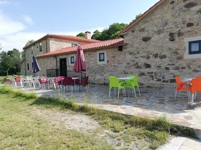 a group of chairs and tables in front of a building at Hosteria Calixtino in Palas de Rei