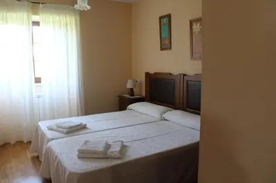 a bedroom with a bed with two towels on it at Apartamentos Casa Cerolleiro in Castropol