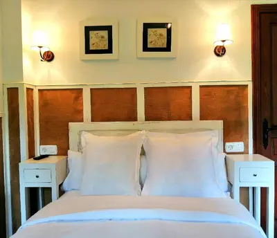 a bedroom with a white bed with two night stands at Las Rocas in Vega de Valcarce