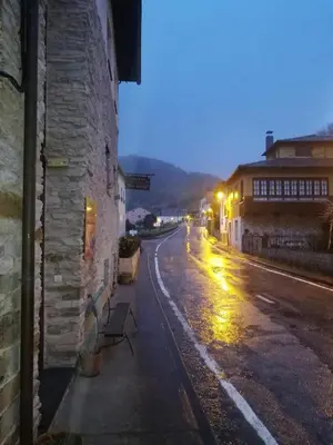 an empty street with a bench on the side of a building at Las Rocas in Vega de Valcarce