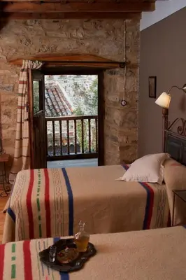 a hotel room with two beds and a window at Casa Pepa Hotel Rural in Santa Colomba de Somoza