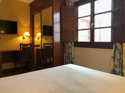 a bedroom with a white bed and a window at Hotel Aroi Bierzo Plaza in Ponferrada