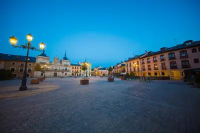 a city square with buildings and street lights at night at Hotel Aroi Bierzo Plaza in Ponferrada