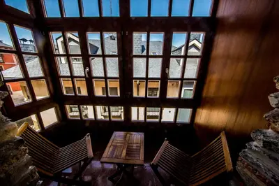 a table and chairs in a room with windows at Hotel Aroi Bierzo Plaza in Ponferrada