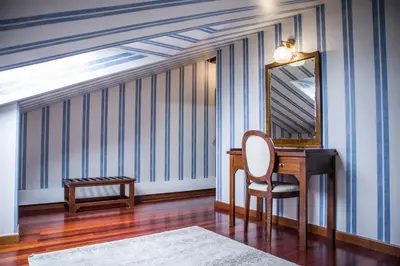 a room with a desk and a chair and a mirror at Hotel A Casa Do Rio in Padrón