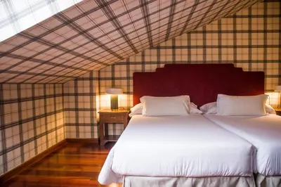 a bedroom with a large white bed in a room at Hotel A Casa Do Rio in Padrón
