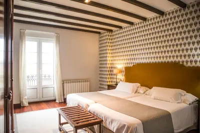 a bedroom with a large bed and a window at Hotel A Casa Do Rio in Padrón