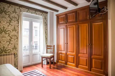 a bedroom with a bed and a chair and a window at Hotel A Casa Do Rio in Padrón