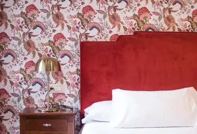 a bedroom with a red headboard and a red wall at Hotel A Casa Do Rio in Padrón