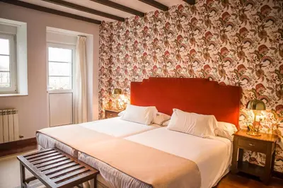 a bedroom with a large bed with a wooden headboard at Hotel A Casa Do Rio in Padrón