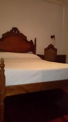 a bedroom with a bed with a wooden headboard at Hotel Los Perales in Puebla de Sanabria