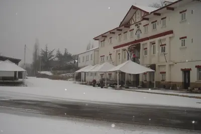 a snow covered street in front of a building at Hotel Los Perales in Puebla de Sanabria