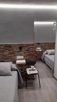 a bedroom with two beds and a table and a mirror at Pension Grilo in Padrón