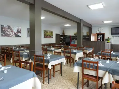 a dining room with tables and chairs with blue table cloth at Pension Grilo in Padrón