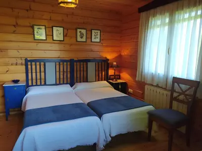 a bedroom with two beds in a log cabin at El Estudio in Ferreirós