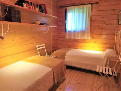 a bedroom with two beds in a log cabin at El Estudio in Ferreirós