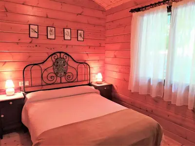 a bedroom with a bed with red wooden walls at El Estudio in Ferreirós