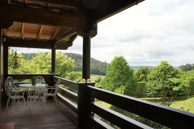 a porch of a cabin with a table and chairs at El Estudio in Ferreirós