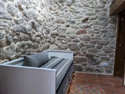 a bench sitting in front of a stone wall at San Andres Ferienhaus mit Gästehaus in Parada del Sil
