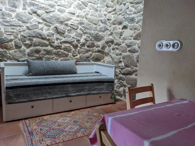 a bedroom with a bed and a stone wall at San Andres Ferienhaus mit Gästehaus in Parada del Sil