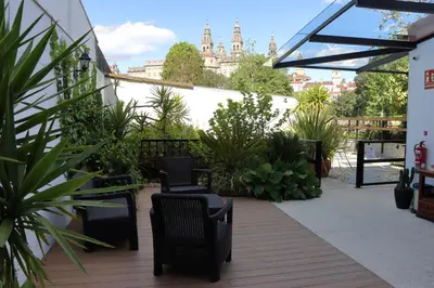 a patio with chairs and plants in a building at Hotel Pazos Alba in Santiago de Compostela