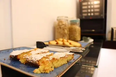 a blue plate with three pieces of cake on a table at Hotel Pazos Alba in Santiago de Compostela