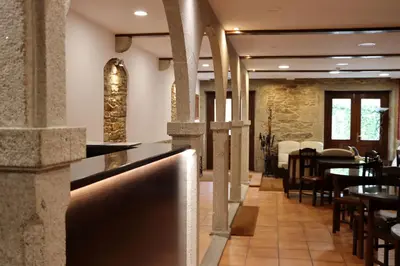 a restaurant with a bar and tables and chairs at Hotel Pazos Alba in Santiago de Compostela