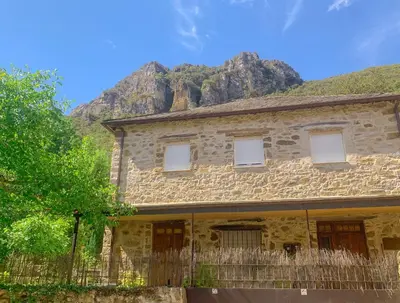 an old stone house with a mountain in the background at Apartamento Las Medulas in Covas