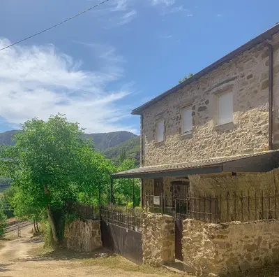 an old stone building with a tree in front of it at Apartamento Las Medulas in Covas