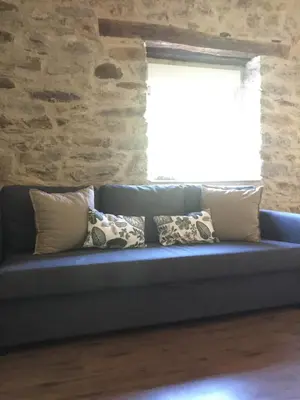 a blue couch with pillows in a room with a window at Apartamento Las Medulas in Covas